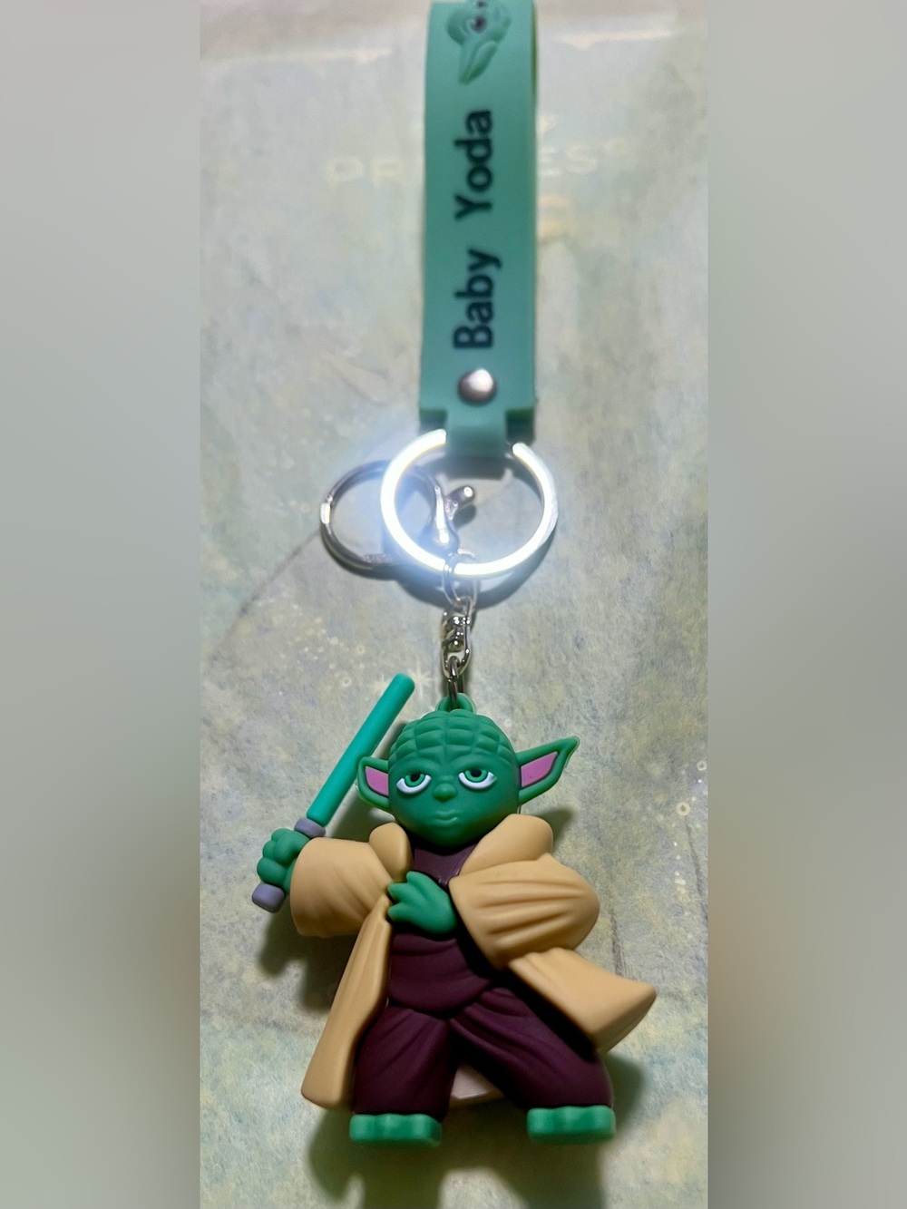 Disney Green and Tan Grogu Keychain with Teal Lightsaber